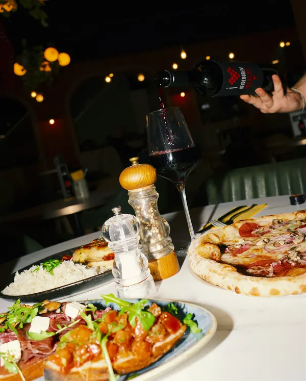 Ein Glas Merlot wird am Tisch eingeschenkt — Abendstimmung im Va Bene
