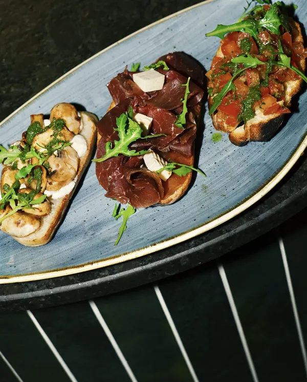 Bruschetta-Trio auf blauem Teller